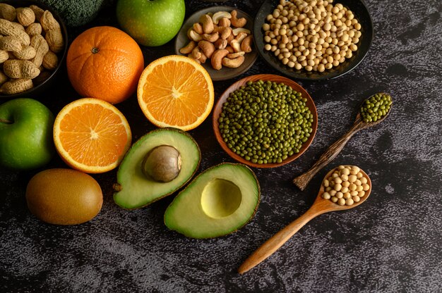 Legumi e frutta su una superficie del pavimento in cemento nero.