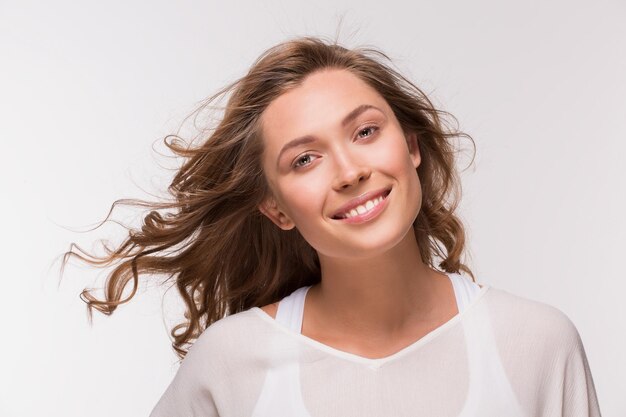 Lei è bella e perfetta. Donna isolata su bianco che sorride alla macchina fotografica.