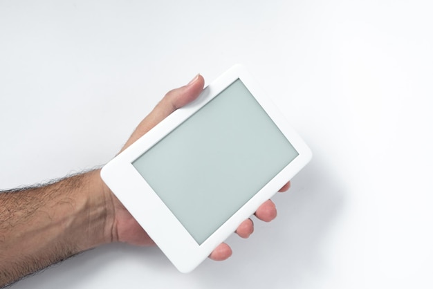 Lettore di ebook su sfondo bianco isolato tenuto da una mano maschile