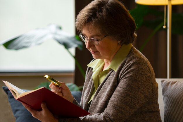 Lettura della donna del colpo medio con il magnifier