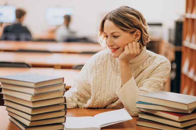 Lettura della giovane donna alla biblioteca