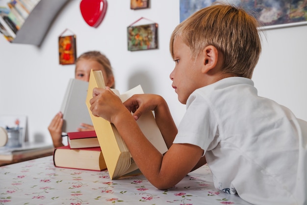 Lettura di ragazzo e ragazza a tavola