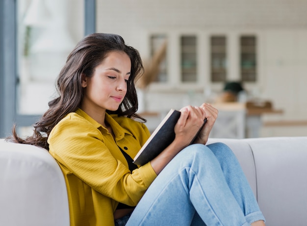 Lettura sveglia della ragazza del brunette di vista laterale