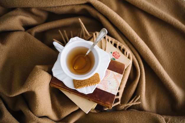 Libri e tè sulla coperta marrone