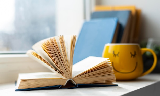 Libro aperto e tazza di smiley