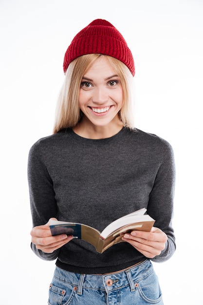 Libro aperto sorridente della tenuta della giovane donna ed esaminare macchina fotografica