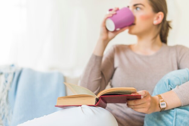 Libro bevente bevente del caffè della donna a casa