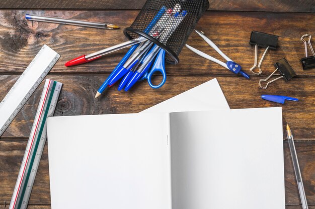 Libro bianco con cartolerie su fondale in legno