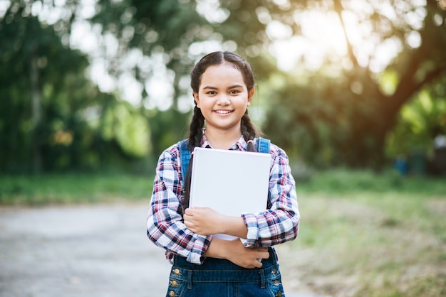 libro di abbraccio di ragazza studente mano