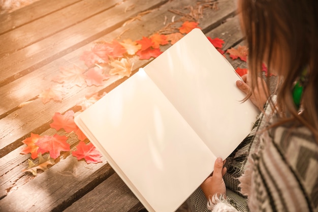 Libro di lettura anonimo della donna nel parco di autunno