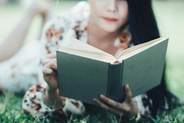 libro di lettura bella ragazza al parco in luce sole estivo