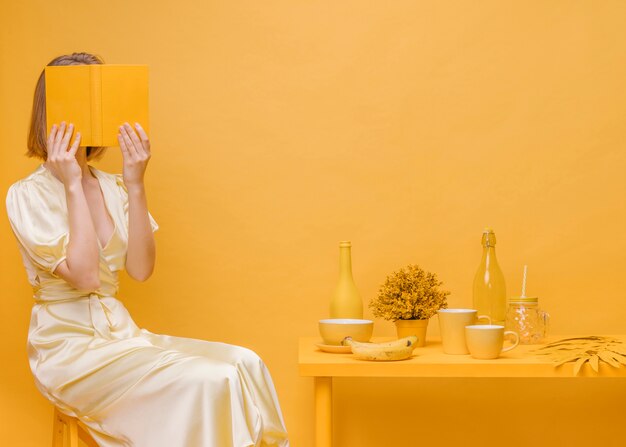 Libro di lettura della donna nella scena gialla
