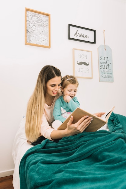 Libro di lettura della figlia e della madre a letto