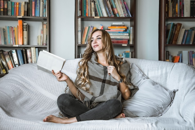 libro di lettura della ragazza sul sofà