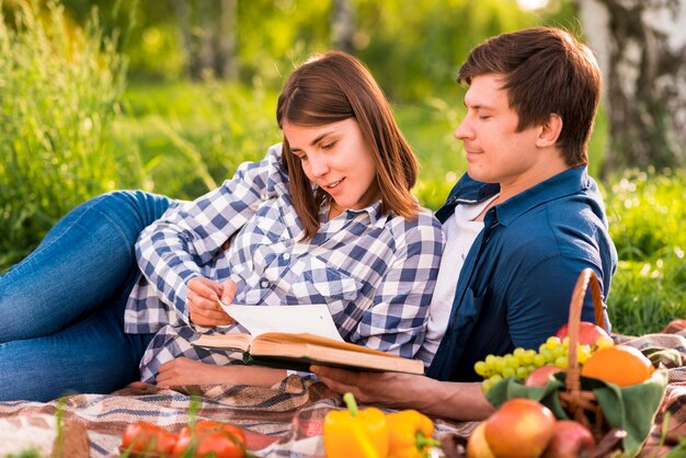 Libro di lettura donna e uomo sul picnic