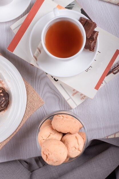 Libro, snack dolci e tazza di tè sul tavolo