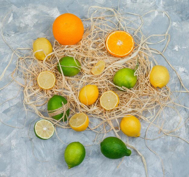 Limes, limoni e arance su una superficie di marmo grigio