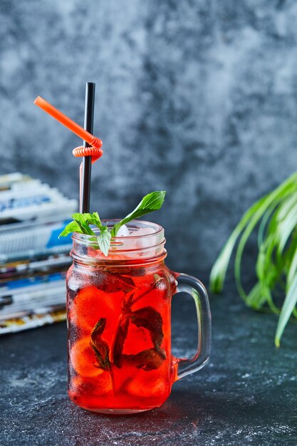 Limonata alla fragola con ghiaccio, menta paglia nella superficie scura