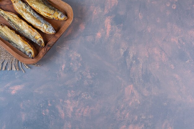 Limoni a fette e pesce sotto sale su un tagliere su un tovagliolo di tela, sulla superficie del marmo