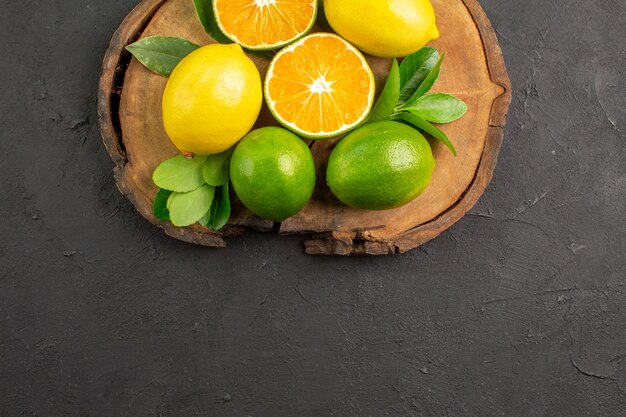 Limoni freschi acida vista dall'alto su calce di agrumi frutta pavimento scuro