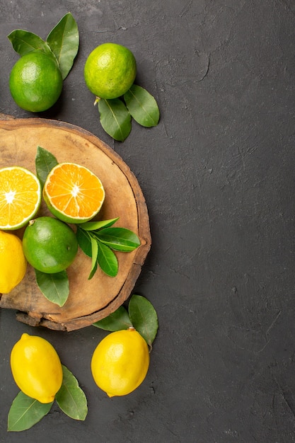 Limoni freschi vista dall'alto sul tavolo scuro limette agrumi di frutta acida