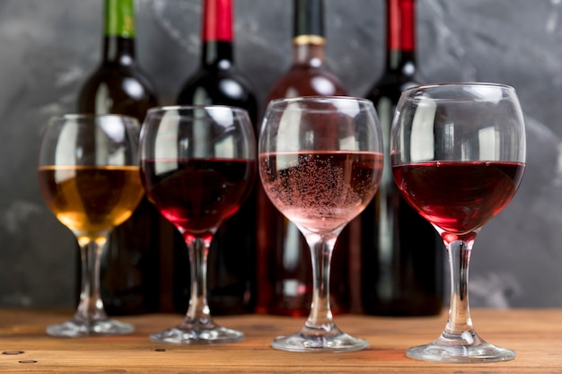 Linea di bottiglie di vino e bicchieri da vino