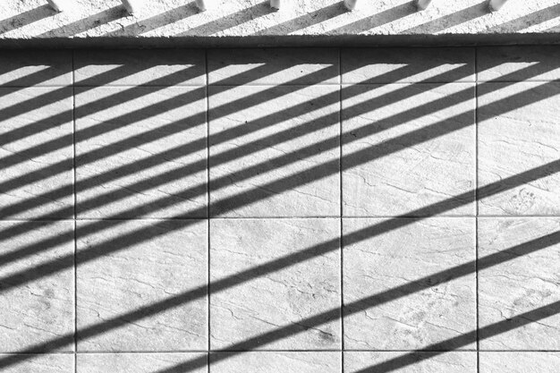 Linee d'ombra perpendicolari sul muro di cemento