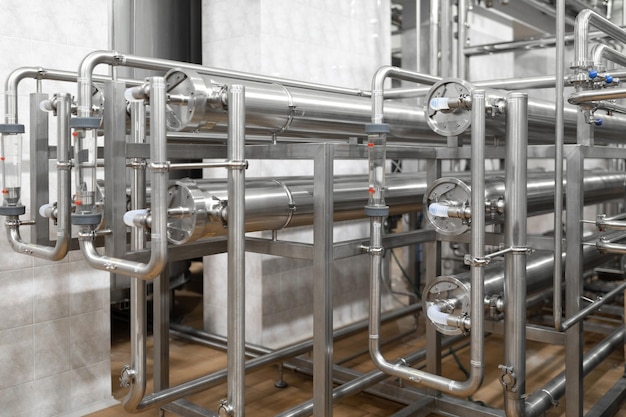 Linee di tubi interne della fabbrica di birra moderna e altri strumenti di attrezzatura nell'officina dell'impianto Sfondo industriale Primo piano di tubi metallici Vista interna dell'impianto industriale Labirinto di tubi sullo sfondo