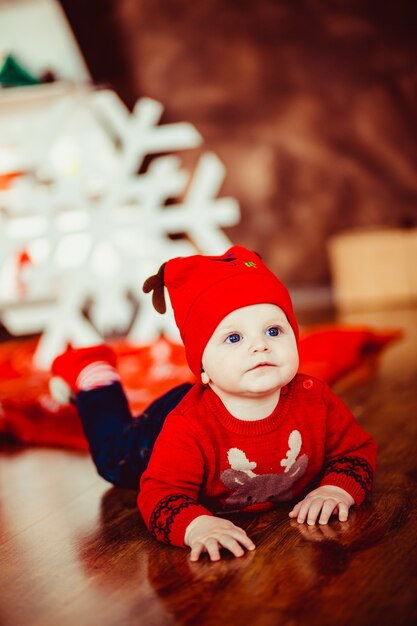 Little boy gioca vicino ad un albero di Natale