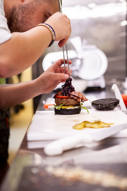 Lo chef esegue come fare il corretto buger. Cibo delizioso