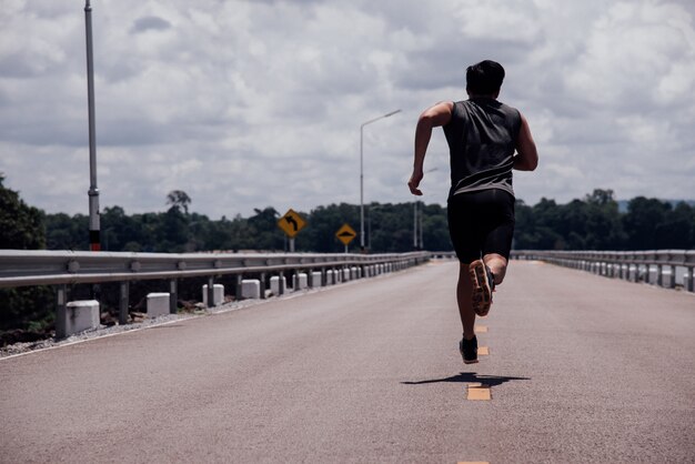 Lo sport uomo con corridore in strada correrà per l&#39;esercizio