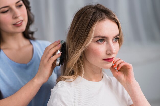 Lo stilista raddrizza la donna bionda dei capelli