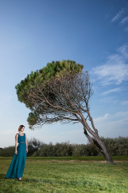 Lonely donna che cammina attraverso il prato