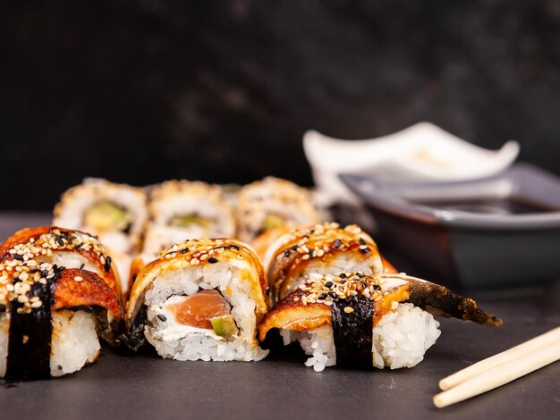 Lotto mix di varietà di rotoli di sushi su sfondo di pietra nera in foto in studio