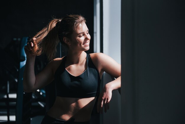 Luce solare calda. splendida donna bionda in palestra durante il suo weekend