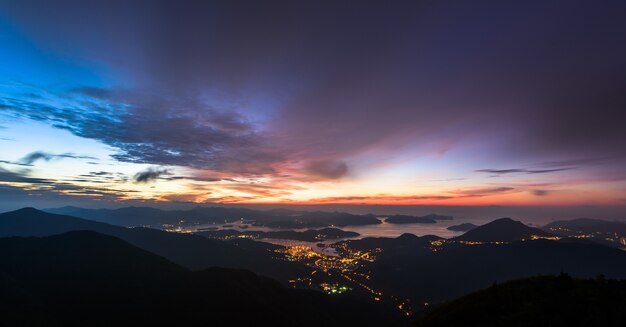 Luci della città e montagne durante il tramonto