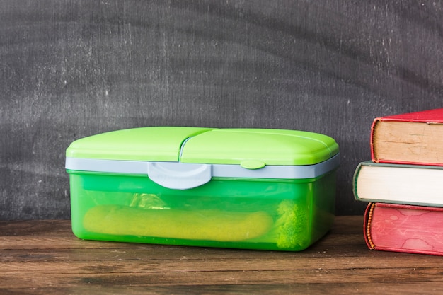 Lunchbox di plastica vicino ai libri di testo