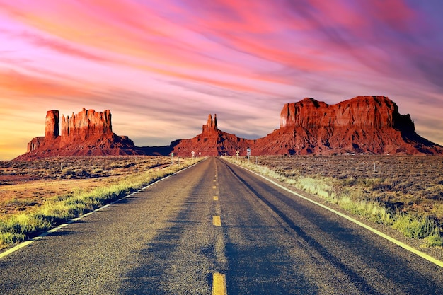 Lunga strada alla Monument Valley al tramonto