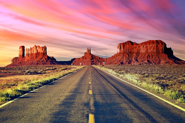 Lunga strada alla Monument Valley al tramonto