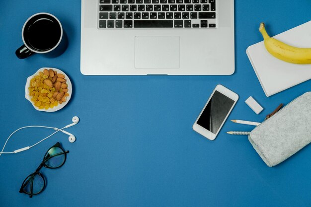Luogo di lavoro blu con frutta per laptop e tazza da tè nera Vista dall'alto Disposizione piatta