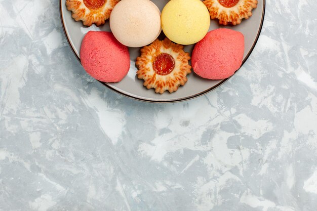Macarons francesi vista dall'alto con biscotti su superficie bianca chiara
