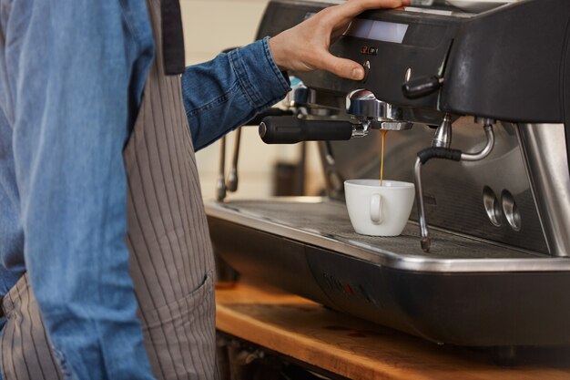 Macchina da caffè professionale. Primo piano del barista che fa la bevanda del caffè.