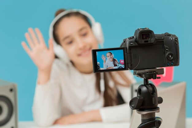 Macchina fotografica del primo piano sulla ragazza della registrazione del treppiede