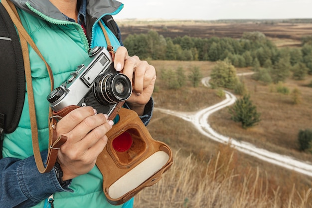 Macchina fotografica della tenuta della donna adulta del primo piano