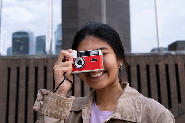 Macchina fotografica della tenuta della donna del colpo medio