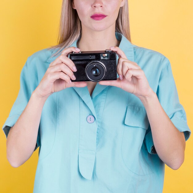 Macchina fotografica della tenuta della donna irriconoscibile