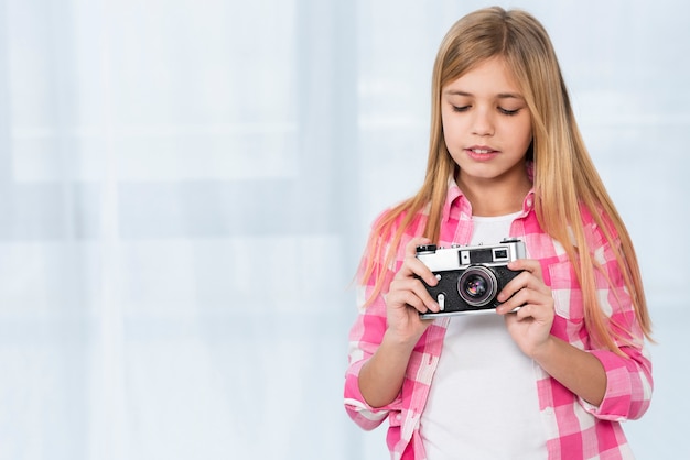 Macchina fotografica della tenuta della ragazza