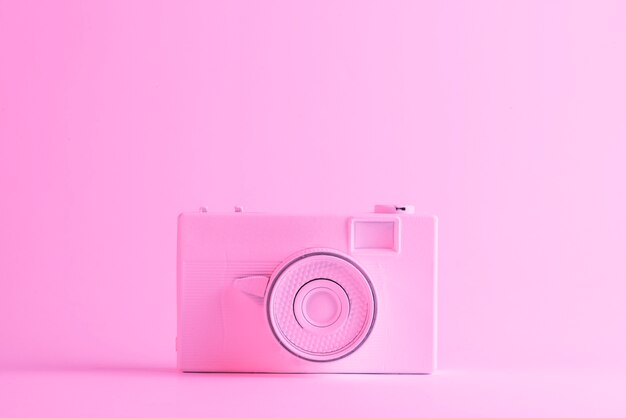Macchina fotografica dipinta su sfondo rosa con copyspace per scrivere il testo