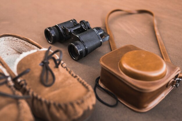 Macchina fotografica e binocolo vicino alle scarpe