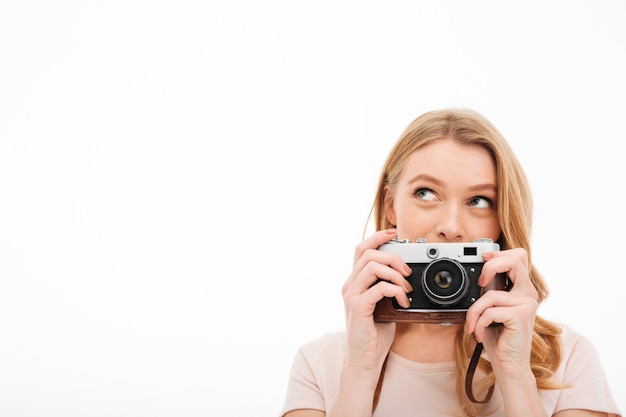 Macchina fotografica sveglia della tenuta della giovane donna.